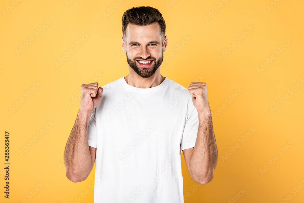 excited man in white t-shirt showing yes gesture isolated on yellow excited man in white t-shirt showing yes gesture isolated on yellow