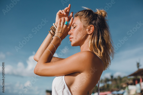 Pretty woman posing in the sea, blue sky, hair wild, victory hand up!, outdoor portrait hipster, fashion model, pretty female, denim shorts, hippie, tattoo, hipster girl, Amsterdam, denim shorts,cute 