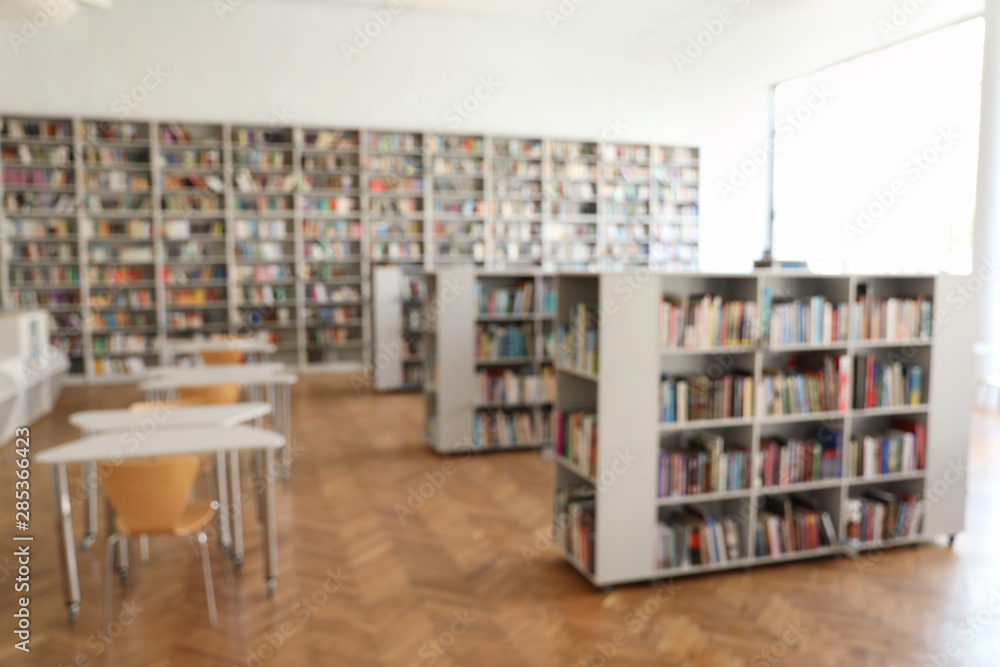 Blurred view of library interior with bookcases and tables Blurred view of library interior with bookcases and tables