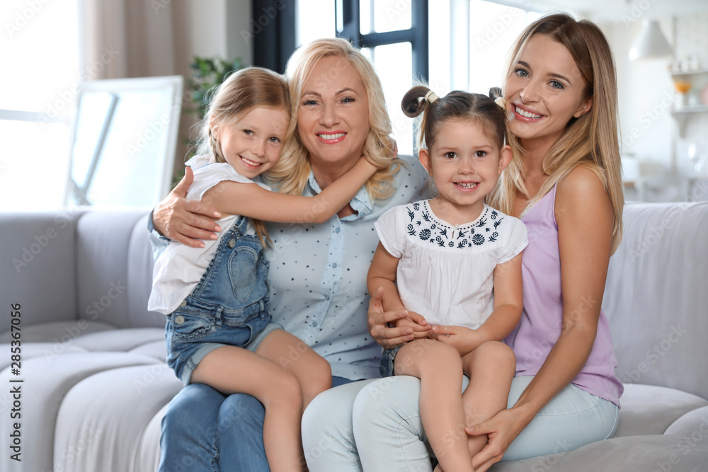 Young woman with mature mother and little daughters in living room Young woman with mature mother and little daughters in living room