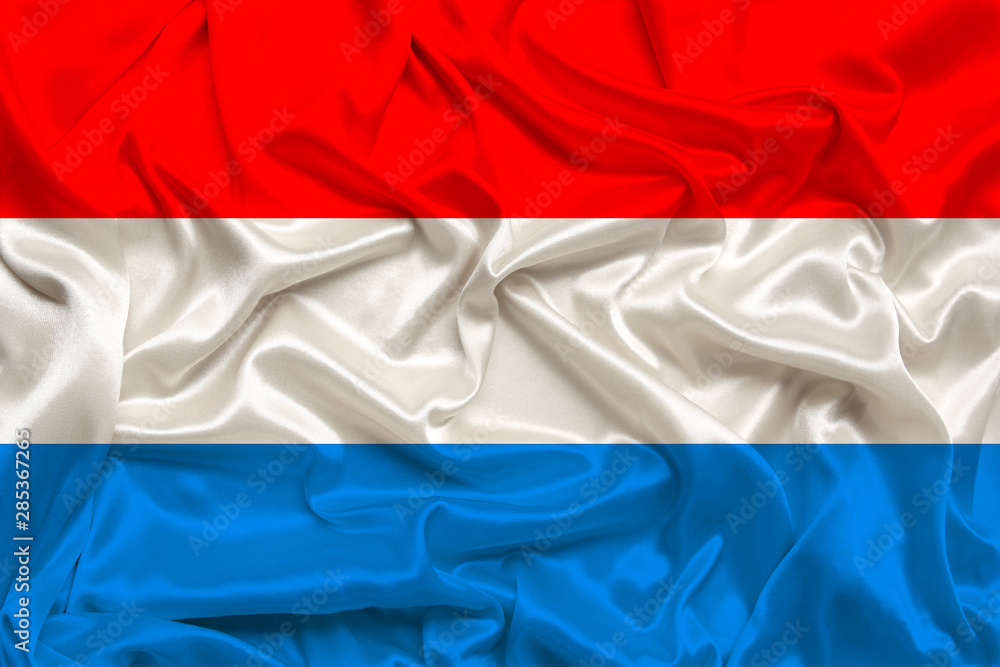 national flag of the Luxembourg on gentle silk with wind folds, travel concept, immigration, politics