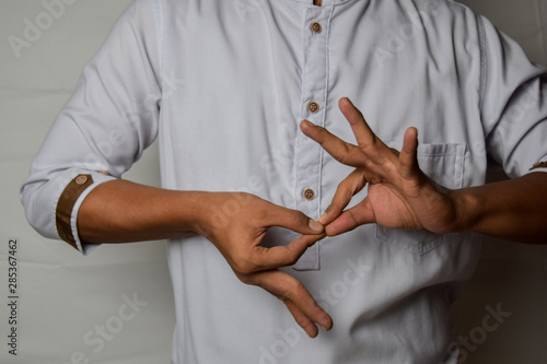 Canvas Print Close up Asian man shows hand gestures it means interpreter appreciation isolated on white background