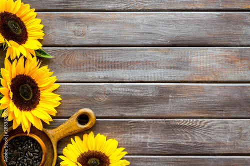 Fototapeta Naklejka Na Ścianę i Meble -  Frame of sunflowers and seeds on wooden background top view mockup