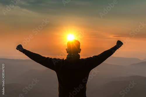 Image is silhouette. Men's travel Mountain view at sunrise happy.Man Tourists wearing glasses and a sweater. Standing atop the mountain at sunrise with fog trees and beautiful..