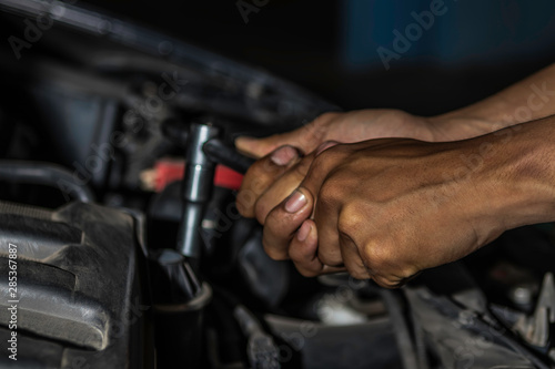 Close up, People are repair a car Use a wrench and a screwdriver to work.