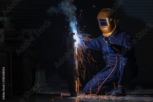 Working person About welder steel Using electric welding machine There are lines of light coming out and safety equipment.