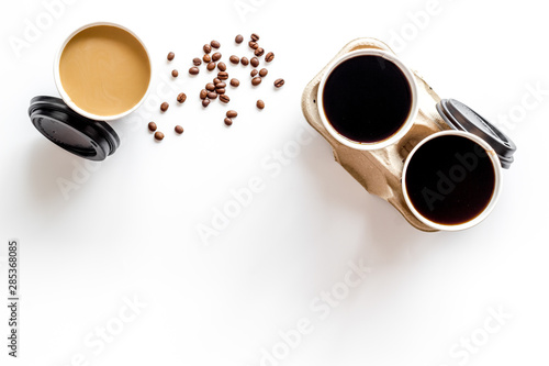 Coffee to take away in paper cups with beans on white table background top view space for text