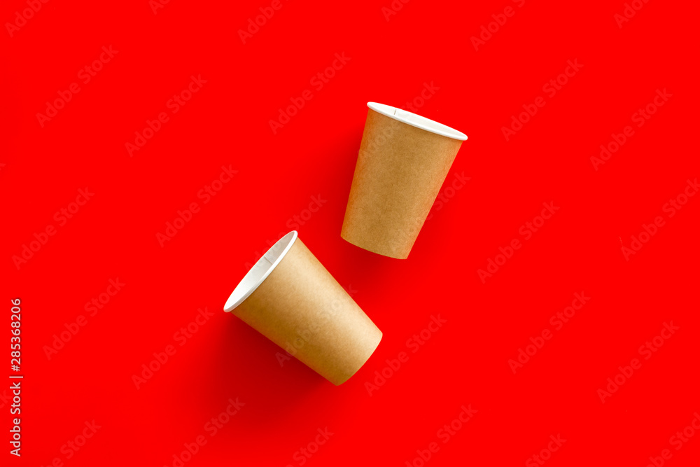 Empty paper cups for coffee to-go from cafe on red background top view mock-up Empty paper cups for coffee to-go from cafe on red background top view mock-up
