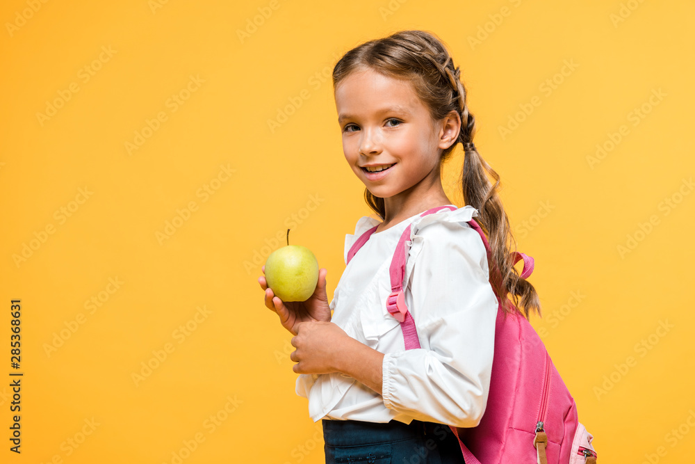 happy schoolchild holding tasty apple isolated on orange happy schoolchild holding tasty apple isolated on orange