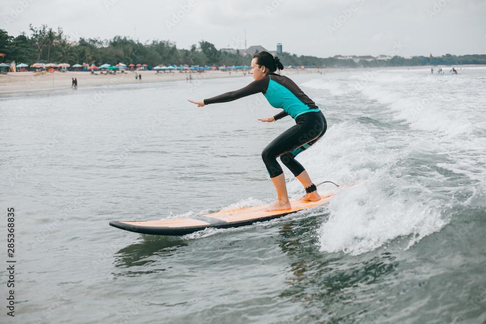 Surfer girl walking with board on the sandy beach. Surfer female.Beautiful young woman at the beach. water sports. Healthy Active Lifestyle. Surfing. Summer Vacation. Extreme Sport. Tattoo woman, Bali Surfer girl walking with board on the sandy beach. Surfer female.Beautiful young woman at the beach. water sports. Healthy Active Lifestyle. Surfing. Summer Vacation. Extreme Sport. Tattoo woman, Bali
