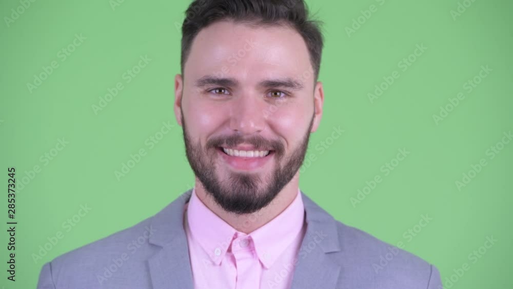 Face of happy young handsome bearded businessman smiling Face of happy young handsome bearded businessman smiling