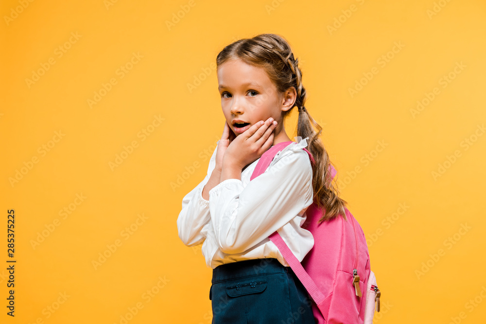 surprised kid touching face and looking at camera isolated on orange surprised kid touching face and looking at camera isolated on orange