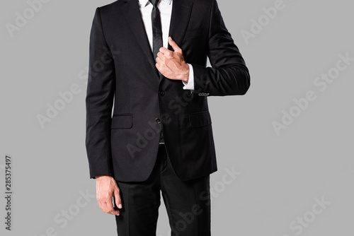 partial view of elegant businessman in black suit and tie isolated on grey