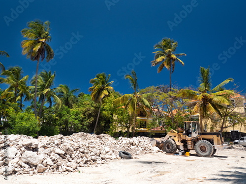 Excavator on construction site with pile of stones