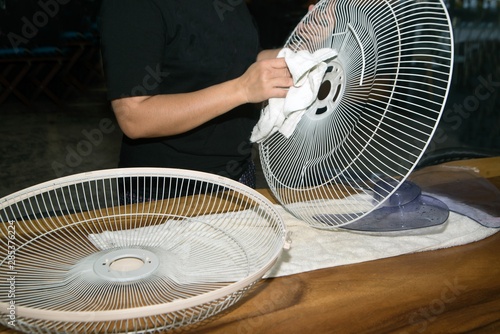 Housekeeper use white cloth Wipe and clean the electric fan.