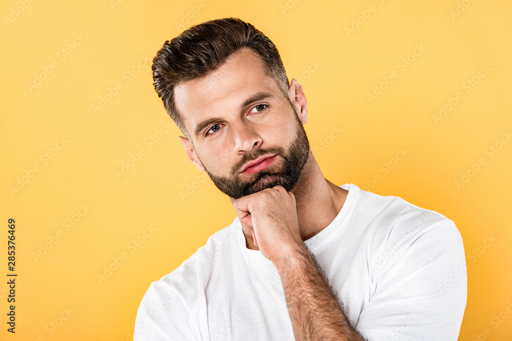 pensive handsome man in white t-shirt looking away isolated on yellow pensive handsome man in white t-shirt looking away isolated on yellow