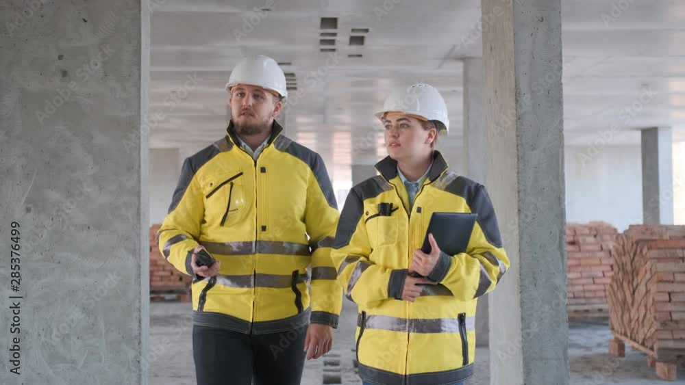 Architect or engineer working, browsing building project indoor of construction site with blueprint plan. businessman worker, man male construction engineers or architects working people. Two Engineer Architect or engineer working, browsing building project indoor of construction site with blueprint plan. businessman worker, man male construction engineers or architects working people. Two Engineer