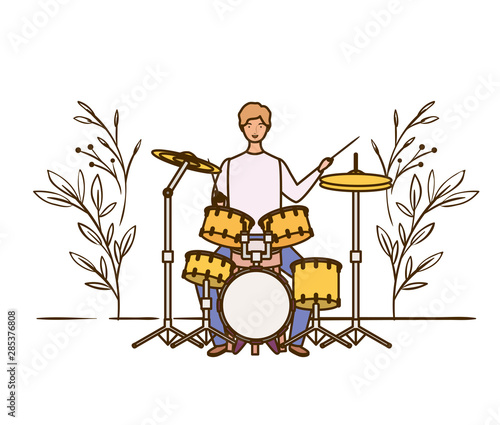 man with drum kit and branches and leaves in the background photo