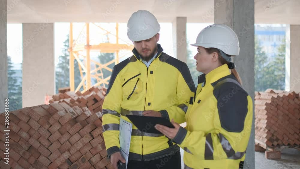Architect or engineer working, browsing building project indoor of construction site with blueprint plan. businessman worker, man male construction engineers or architects working people. Two Engineer Architect or engineer working, browsing building project indoor of construction site with blueprint plan. businessman worker, man male construction engineers or architects working people. Two Engineer