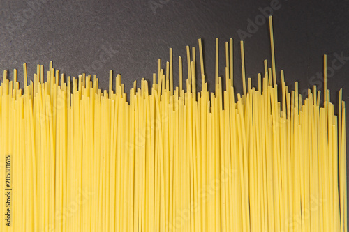 Raw Italian spaghetti pasta on gray background