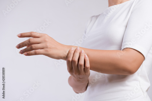 Closeup woman holds her wrist hand injury, feeling pain. Health care and medical conept. © Siam