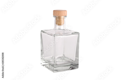 A glass transparent empty bottle with a wooden plug on a white background. Isolated