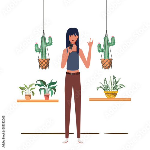 woman with microphone with stand and houseplants on macrame hangers of background