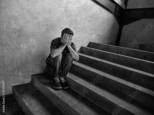 Fotografia desperate man sitting outdoors on dark grunge street corner staircase feeling si