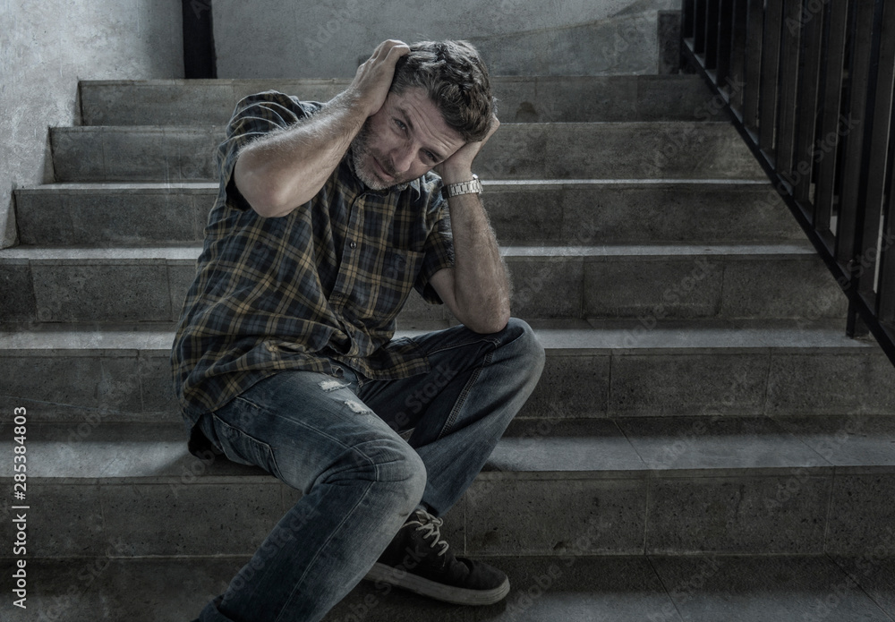 dramatic portrait of young depressed and paranoid man on dark grunge street corner staircase feeling sick suffering depression and anxiety crisis dramatic portrait of young depressed and paranoid man on dark grunge street corner staircase feeling sick suffering depression and anxiety crisis
