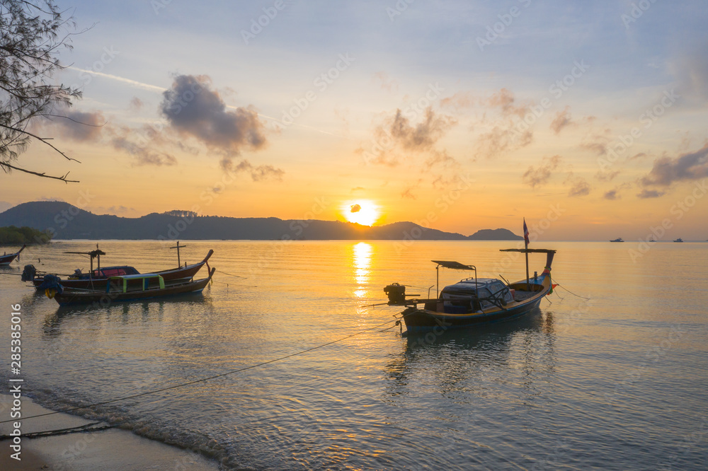 aerial view sunrise above fishing boats parking near the beach.