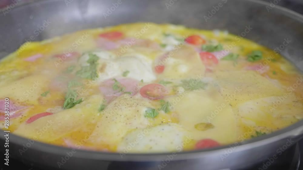 Omelet with cheese and vegetables baking in a skillet Omelet with cheese and vegetables baking in a skillet