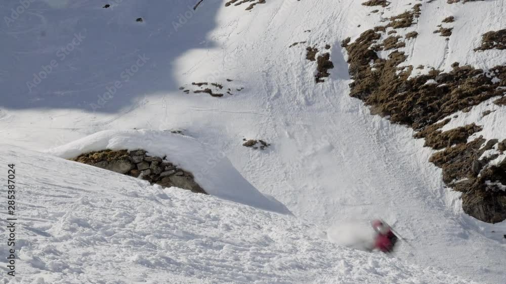 Female freeride skier crash when doing a 360 on skis down from a cliff in the alps in Salzburg Austria Female freeride skier crash when doing a 360 on skis down from a cliff in the alps in Salzburg Austria