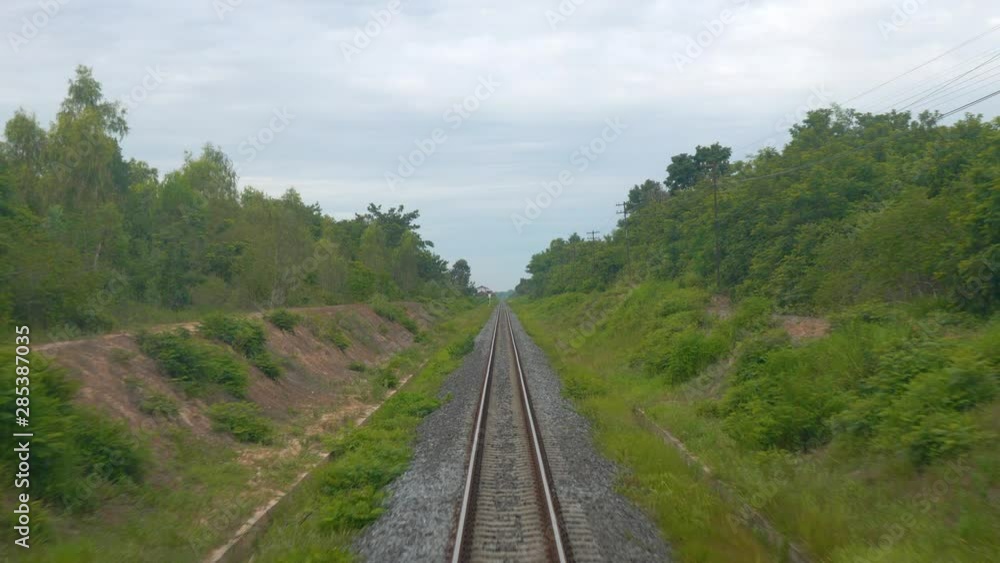 Single railway track on embankment crossing lush green landscape, slow motion Single railway track on embankment crossing lush green landscape, slow motion