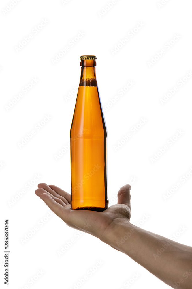 male hand holding brown beer bottle without label isolated on white background. man offers a bottle of beer male hand holding brown beer bottle without label isolated on white background. man offers a bottle of beer