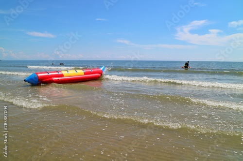 Soft focus of beautiful view of the waves at the beach with banana boat and blue sky with reflection in summer morning. Nature background concept.