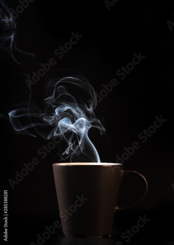 coffee brown mug and smoke on black background