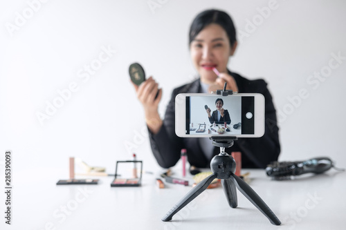 Business online on social media, Beautiful woman blogger is showing present tutorial beauty cosmetic product and broadcast live streaming video to social network while recording teaching online