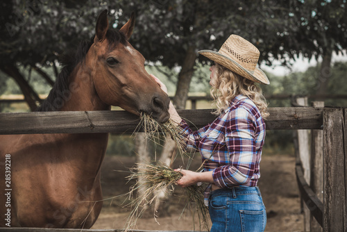 Woman with a horses on farm, pets animals in village on a rancho. Horses are human friends 