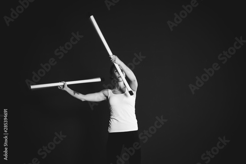 Juggler girl on black background, woman training  