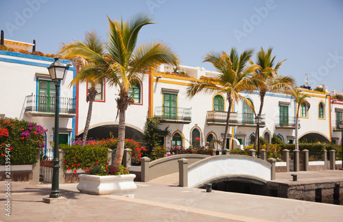 Gran Canaria, Spain - Typical architecture of Puerto de Mogan, a small fishing port of Gran Canaria. Colorfull flowers blooming around houses. © natapro