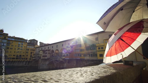 View at the river of Ponte Vecchio in Florence with a nice red umbrella at the end of the shot photo