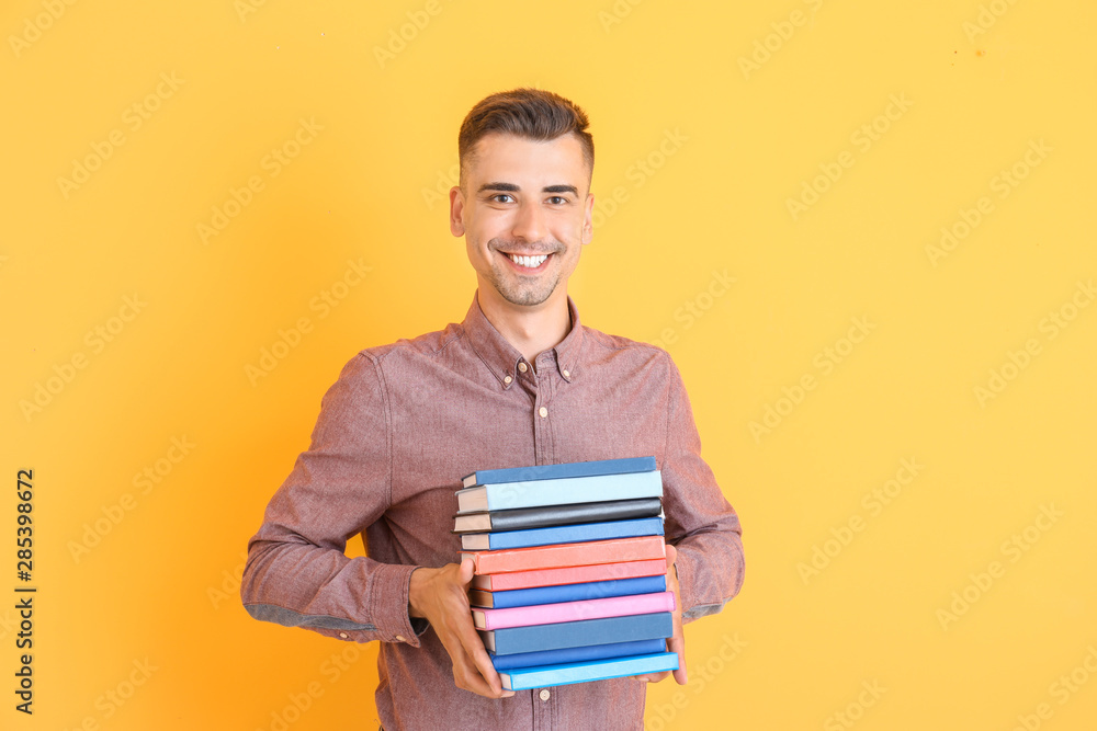 Handsome male teacher with books on color background Handsome male teacher with books on color background