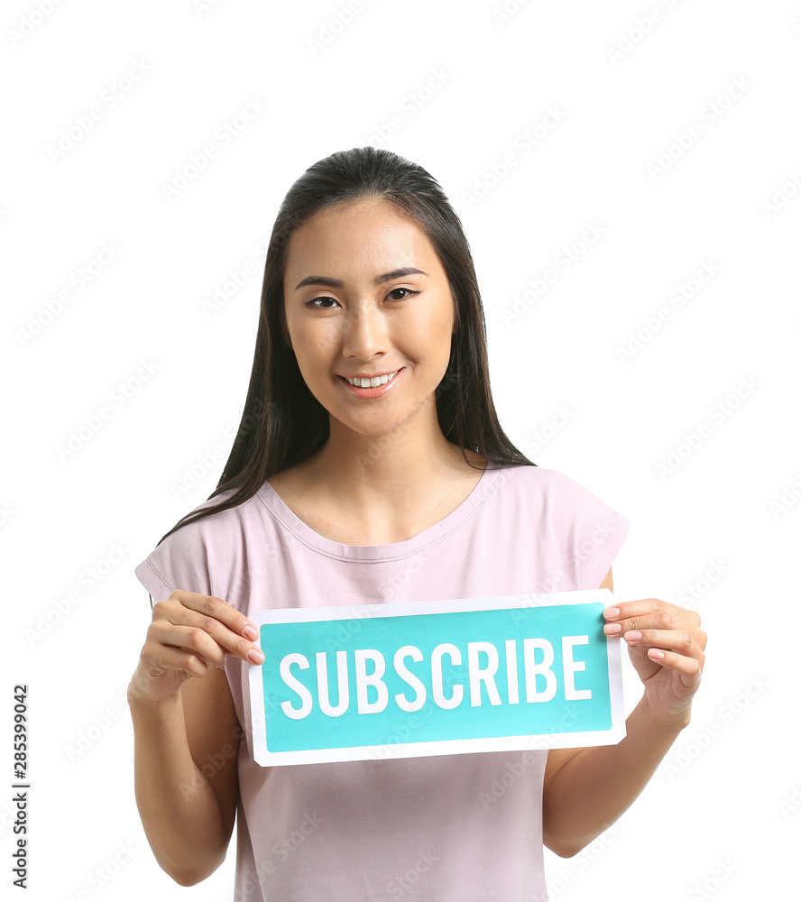 Female Asian blogger holding paper with text SUBSCRIBE on white background Female Asian blogger holding paper with text SUBSCRIBE on white background
