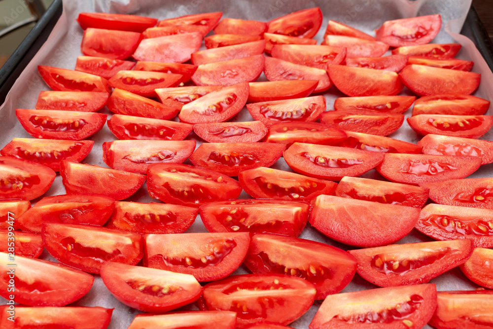 Homemade dried red tomatoes slices with basil oregano spices cooking process. Traditional Italian Mediterranean kitchen cuisine. Homemade dried red tomatoes slices with basil oregano spices cooking process. Traditional Italian Mediterranean kitchen cuisine.
