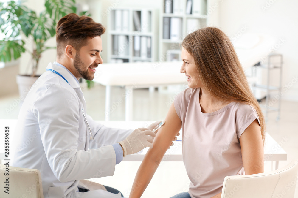 Fototapeta premium Doctor vaccinating young woman in clinic