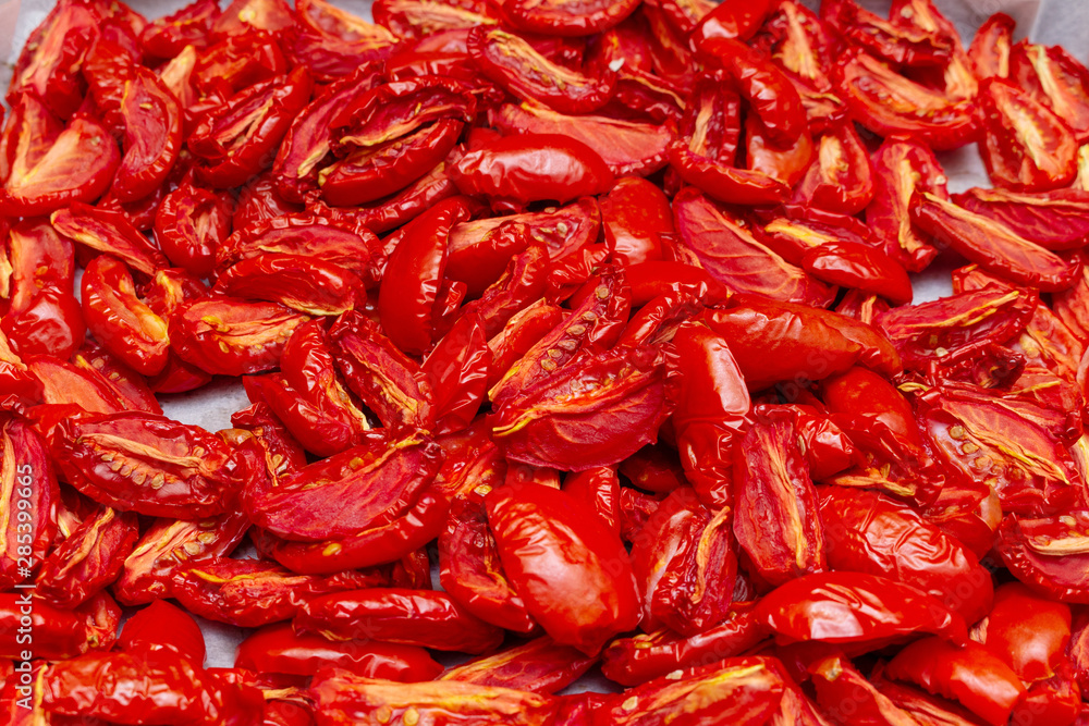 Homemade dried red tomatoes slices with basil oregano spices cooking process. Traditional Italian Mediterranean kitchen cuisine. Homemade dried red tomatoes slices with basil oregano spices cooking process. Traditional Italian Mediterranean kitchen cuisine.