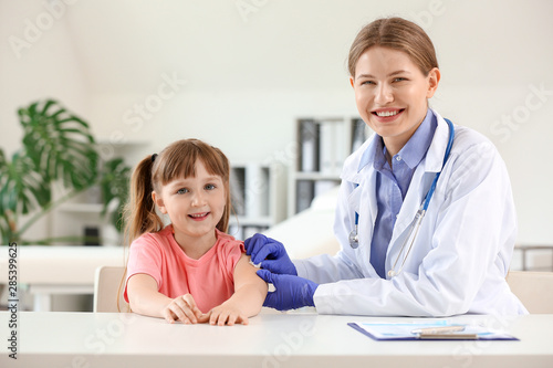 Doctor vaccinating little g...
