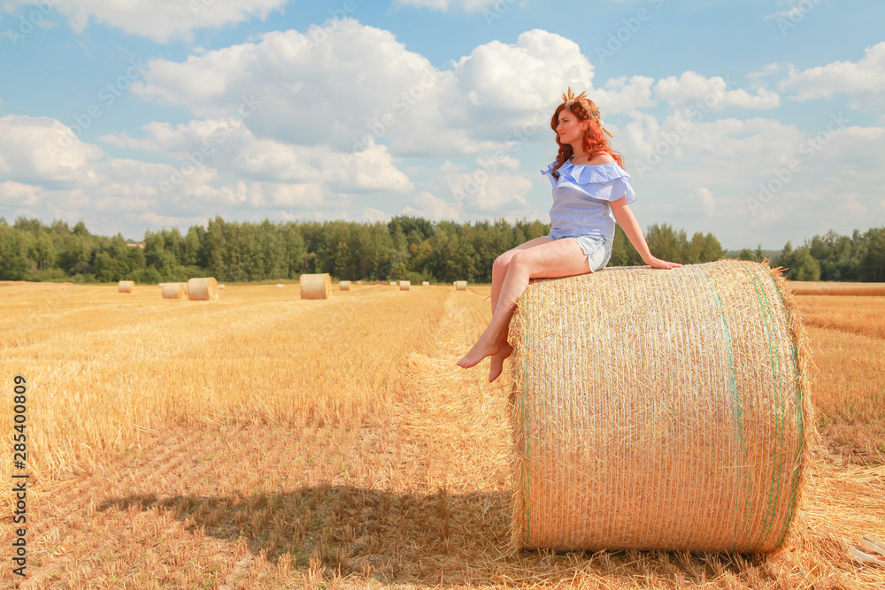 Woman in the autumn field landscape. Haystask rolls on agriculture field. Woman in the autumn field landscape. Haystask rolls on agriculture field.