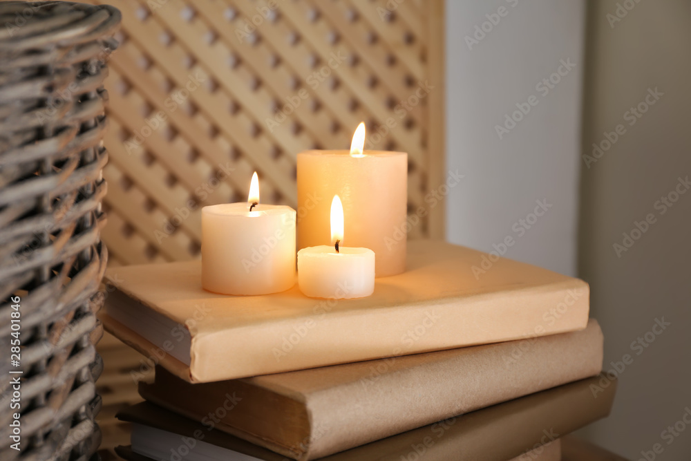 Beautiful burning candles and books on table Beautiful burning candles and books on table