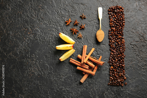 Aromatic cinnamon with coffee beans, anise and apple slices on dark background
